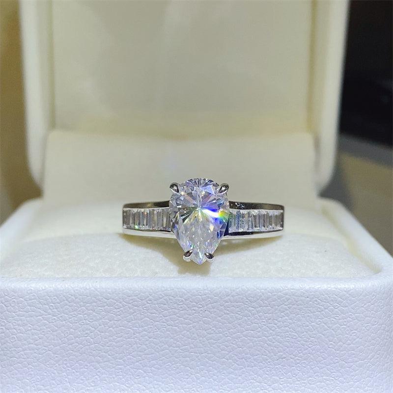 a white gold ring with a pear shaped diamond