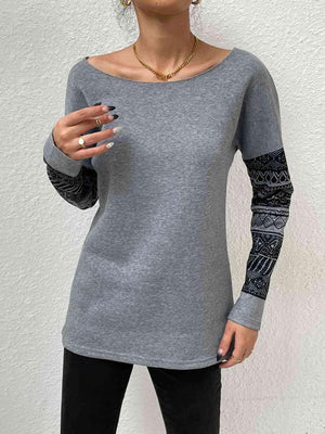 a woman wearing a gray shirt and black pants