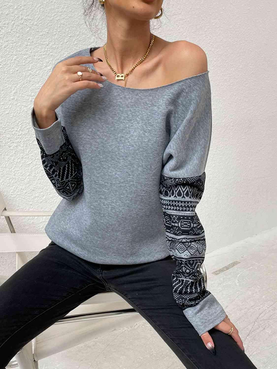 a woman sitting on a white chair wearing a grey sweater