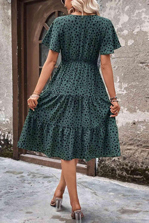a woman wearing a green polka dot dress