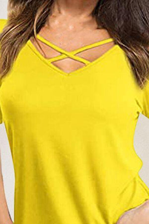 a woman wearing a yellow top with a cross back