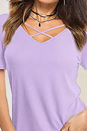a woman wearing a purple top with a cross back