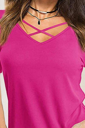 a woman wearing a pink top with a cross back