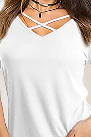 a woman wearing a white top with a cross back