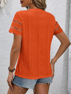 a woman wearing an orange sweater and shorts