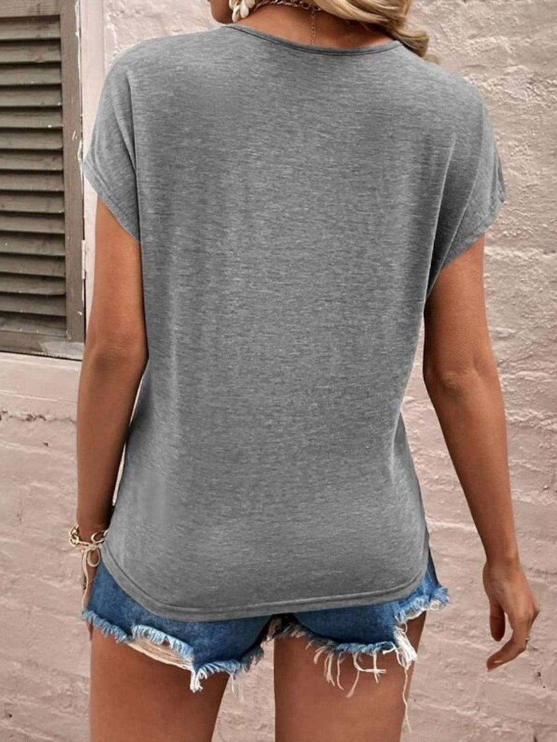 a woman wearing a gray shirt and denim shorts