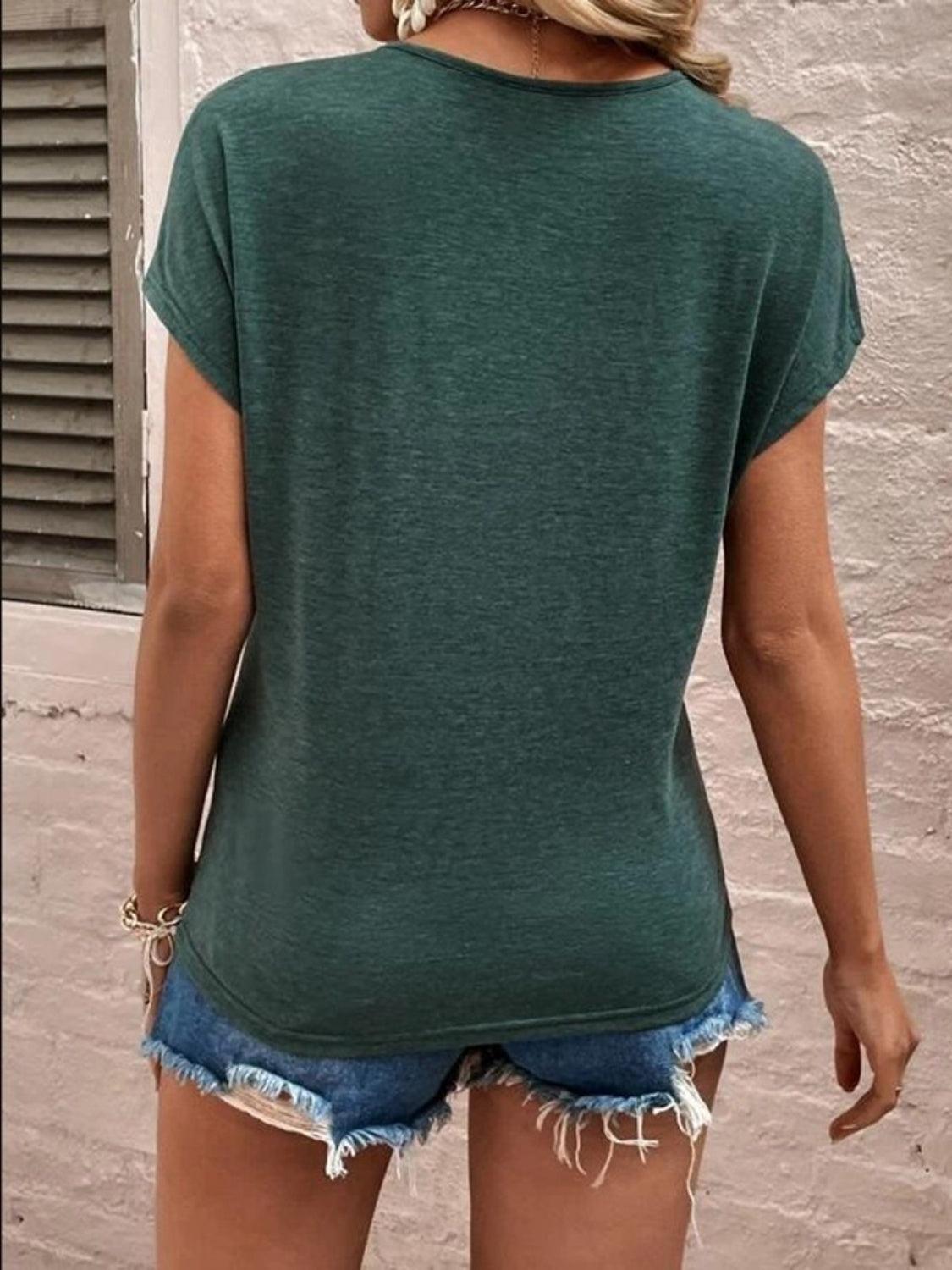 a woman wearing a green shirt and denim shorts