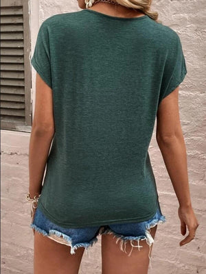 a woman wearing a green shirt and denim shorts