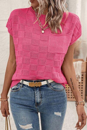 a woman wearing a pink top and ripped jeans