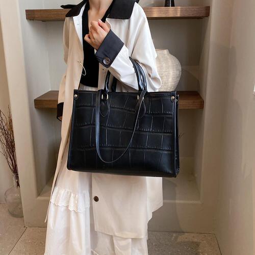 a woman holding a black purse in her hand