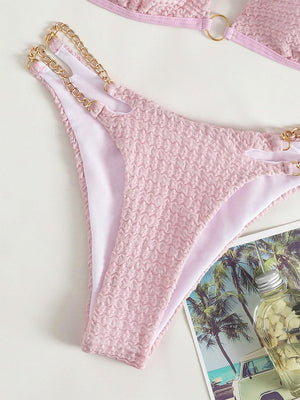 a pink bikini with a gold chain on it