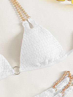 a pair of white bras with gold chains on them