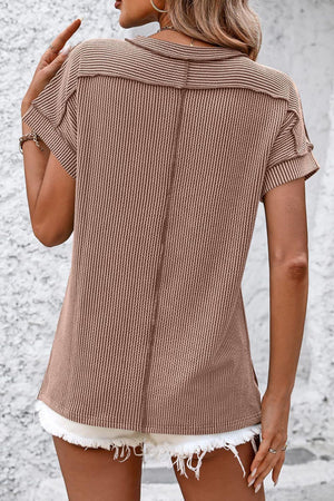 a woman wearing a brown shirt and white shorts