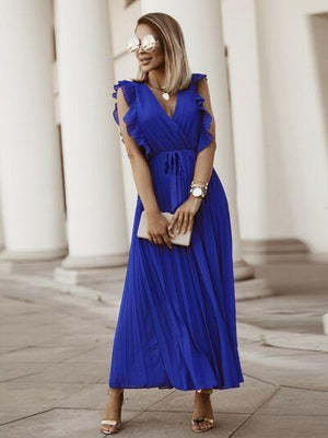 a woman in a blue dress standing on a sidewalk