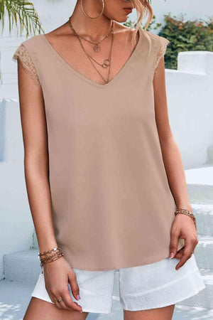 a woman wearing a tan top and white shorts