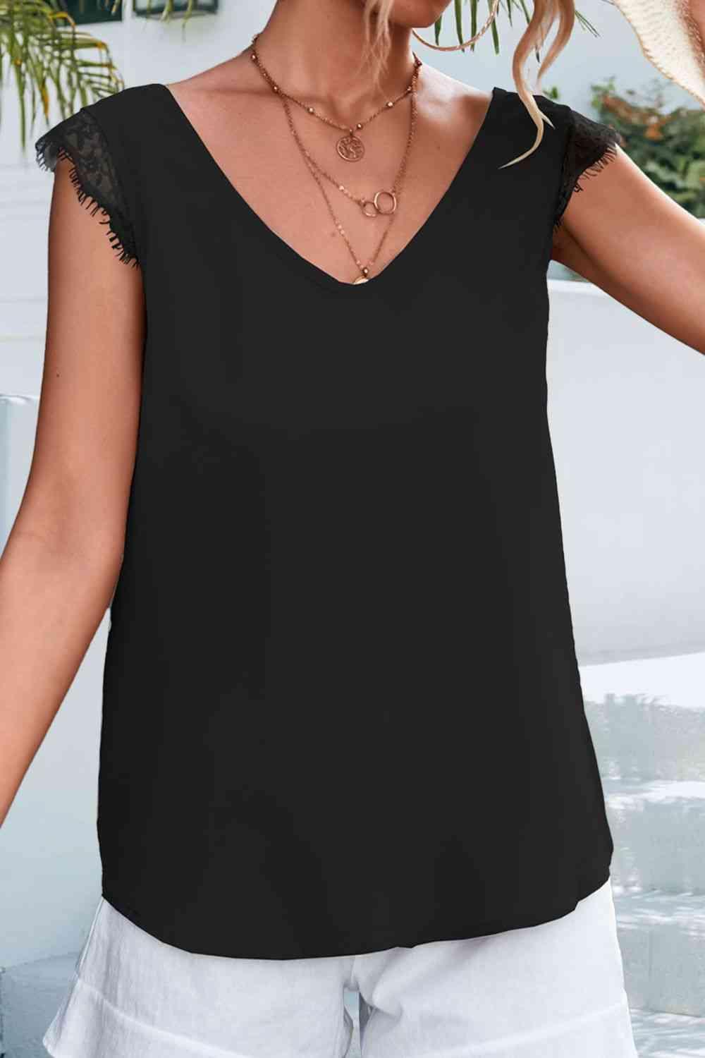 a woman wearing a black top and white shorts