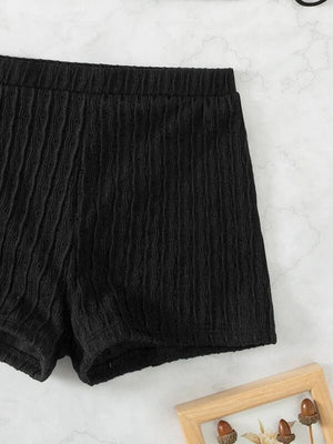 a pair of black shorts sitting on top of a white counter