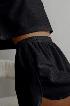 a close up of a person wearing a black top and shorts