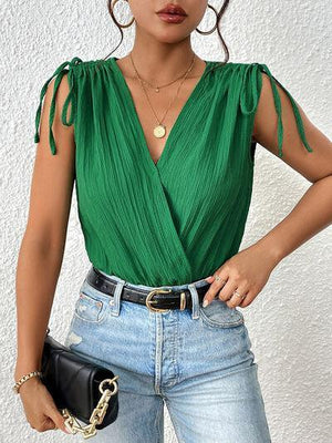 a woman wearing a green top and jeans