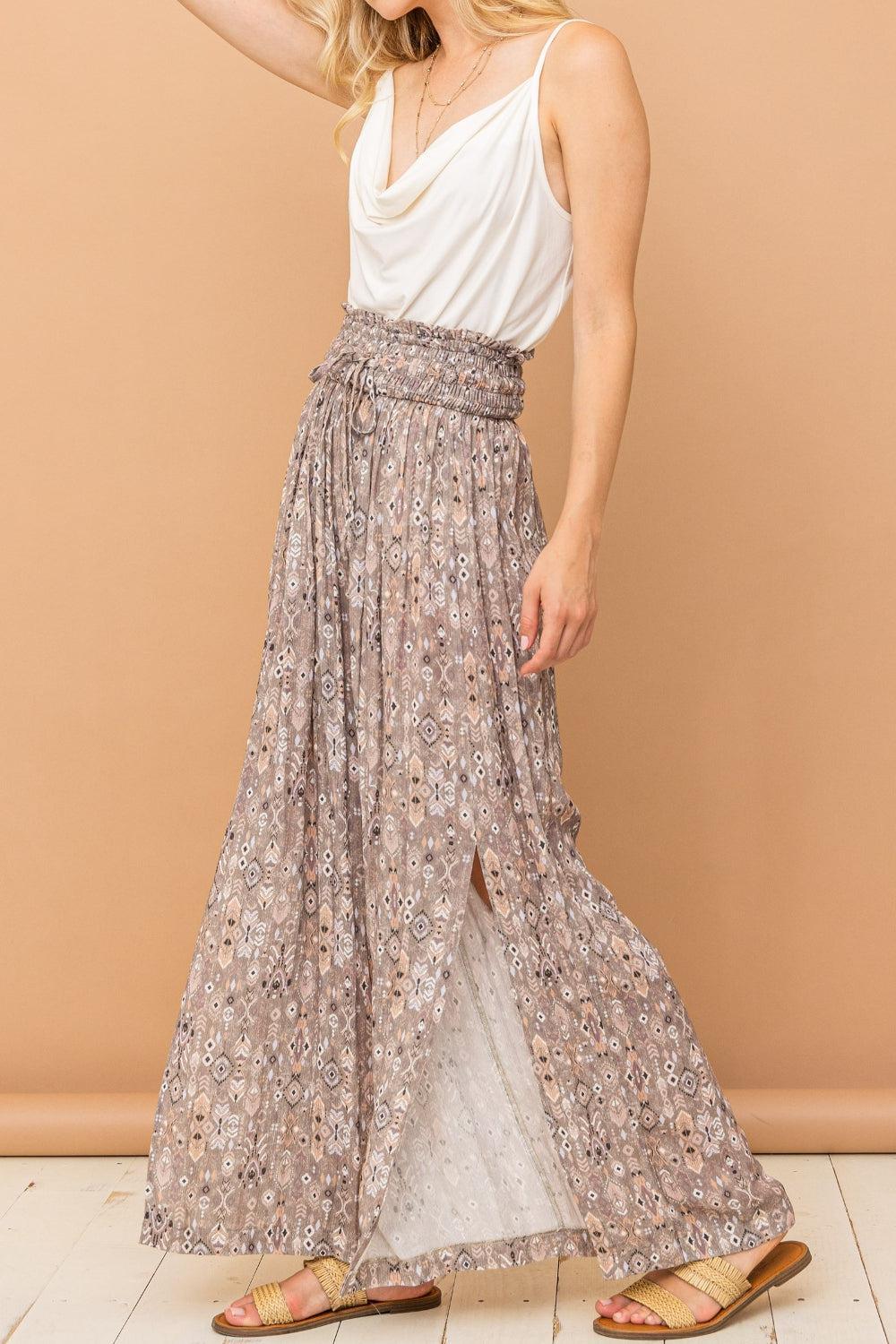 a woman in a white top and a long skirt