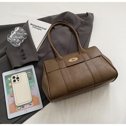 a purse and a cell phone on a bed