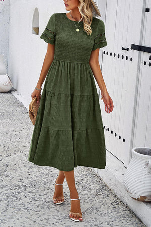 a woman in a green dress is walking down the street