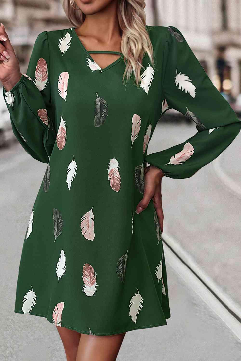 a woman wearing a green dress with feathers on it