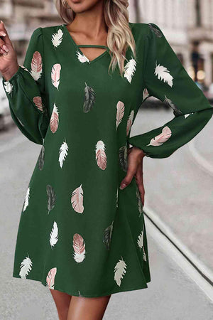 a woman wearing a green dress with feathers on it