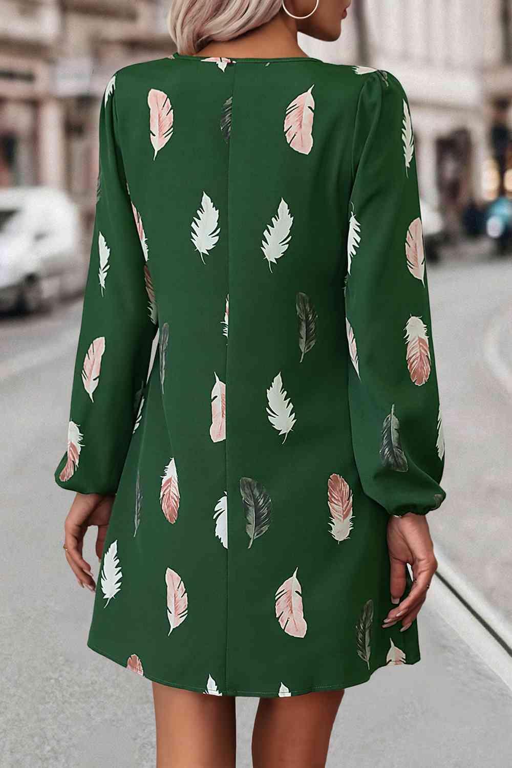 a woman wearing a green dress with leaves on it