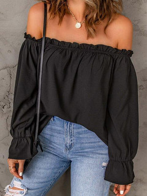 a woman wearing a black off the shoulder top