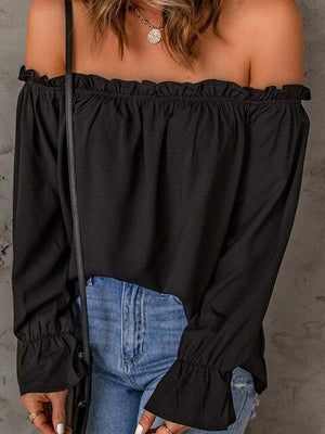 a woman wearing a black off the shoulder top
