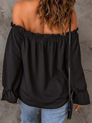 a woman wearing a black off the shoulder top