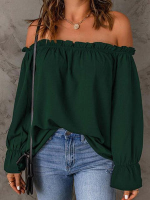 a woman wearing a green off the shoulder top
