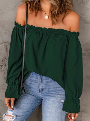 a woman wearing a green top and ripped jeans