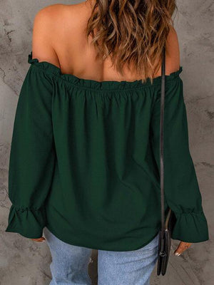 a woman wearing a green off the shoulder top