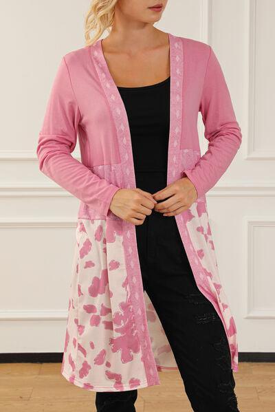 a woman standing in a room wearing a pink cardigan
