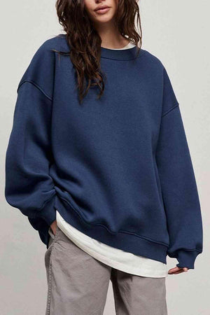 a woman wearing a blue sweatshirt and khaki pants