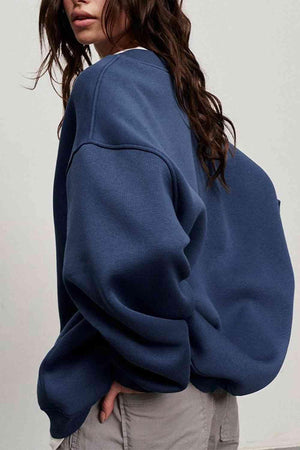 a woman wearing a blue sweatshirt and khaki pants