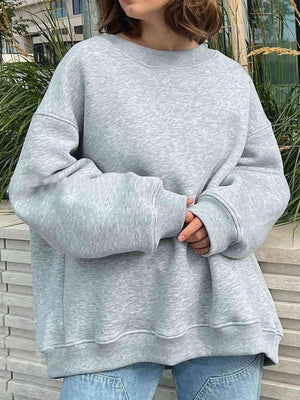 a woman wearing a grey sweatshirt and jeans