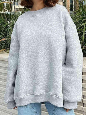a woman wearing a grey sweatshirt and jeans