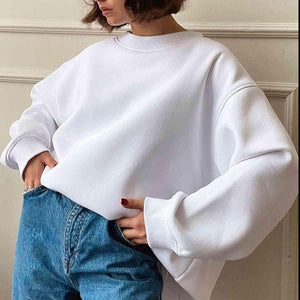 a woman wearing a white sweater and jeans