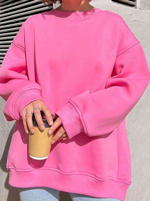 a woman in a pink sweater holding a coffee cup