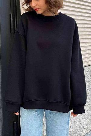 a woman wearing a black sweatshirt and jeans