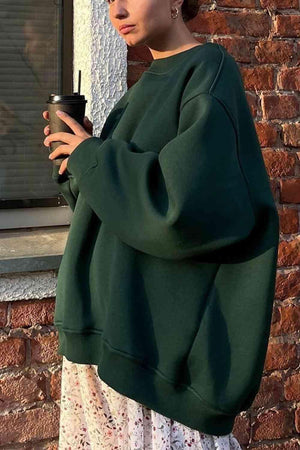 a woman standing in front of a window holding a cup
