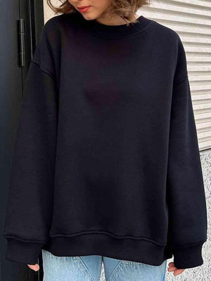 a woman wearing a black sweatshirt and jeans