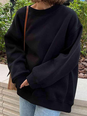 a woman wearing a black sweatshirt and jeans