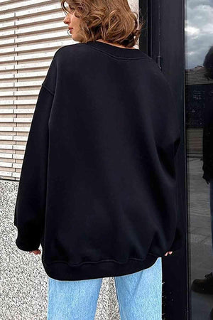 a woman wearing a black sweatshirt and jeans