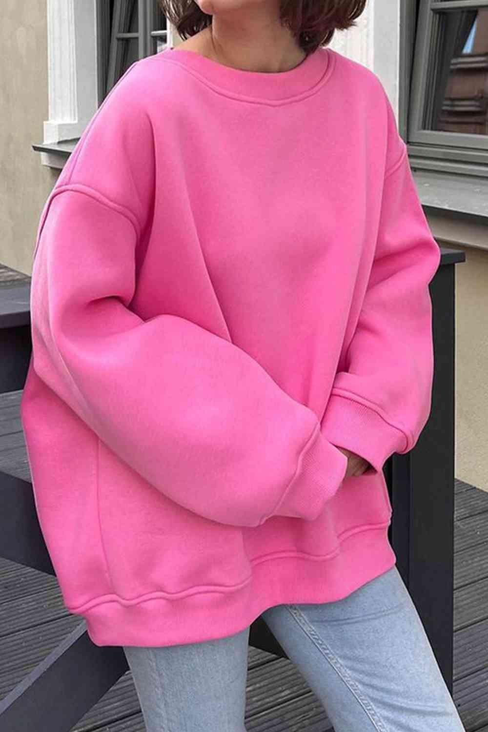 a woman wearing a pink sweatshirt and jeans