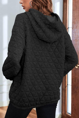 a woman wearing a black quilted jacket
