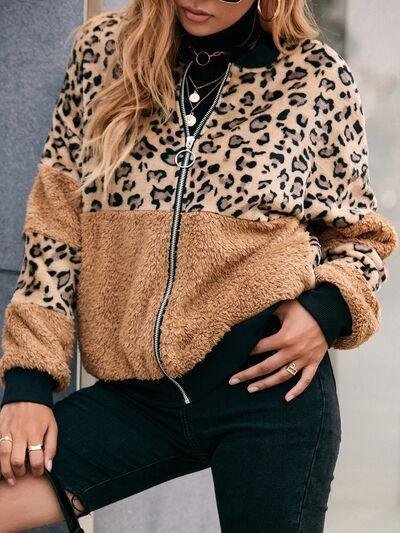 a woman wearing a leopard print jacket and black jeans